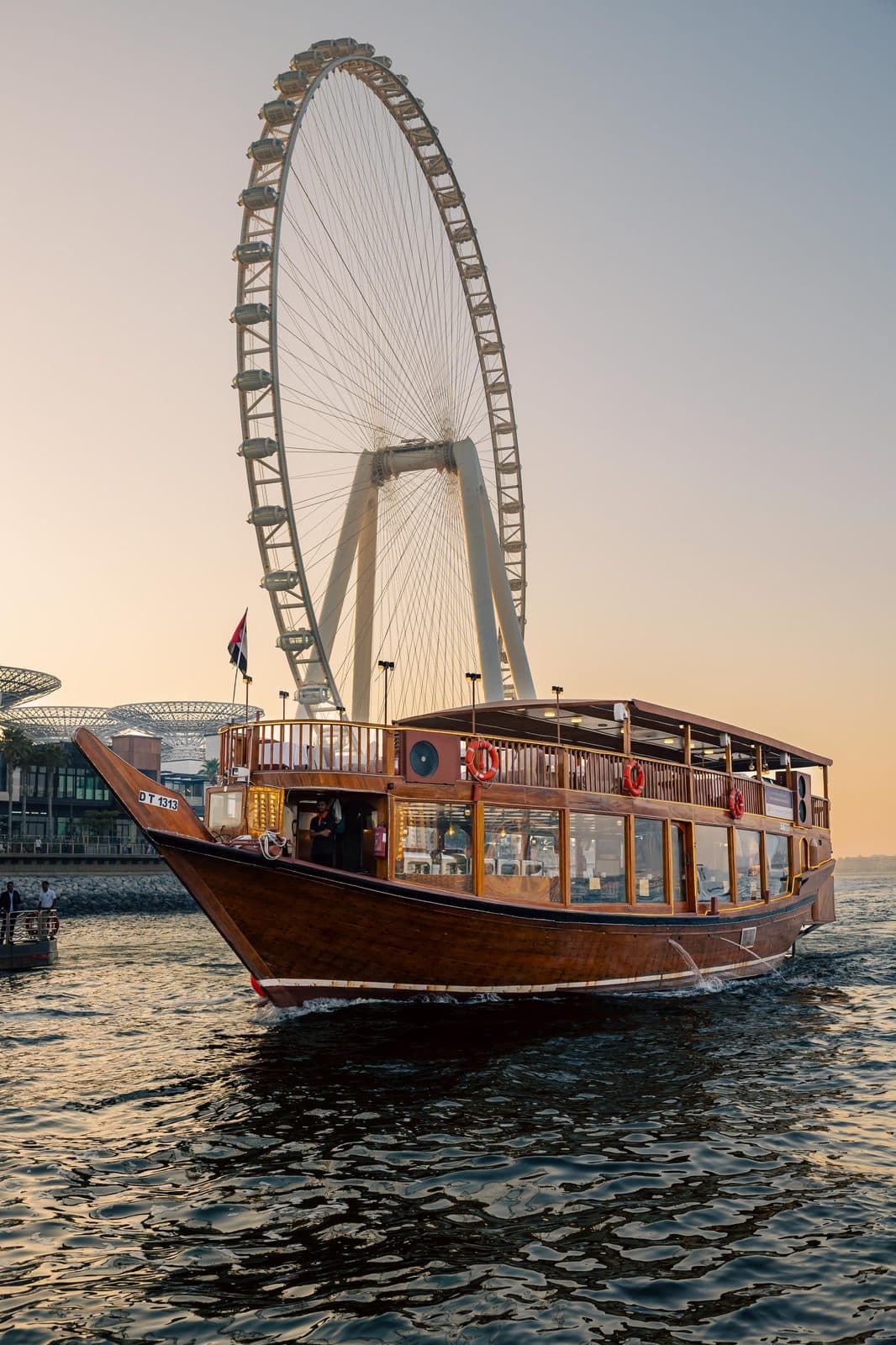 The Alexandra Dhow, a traditional wooden dhow, cruising past Ain Dubai